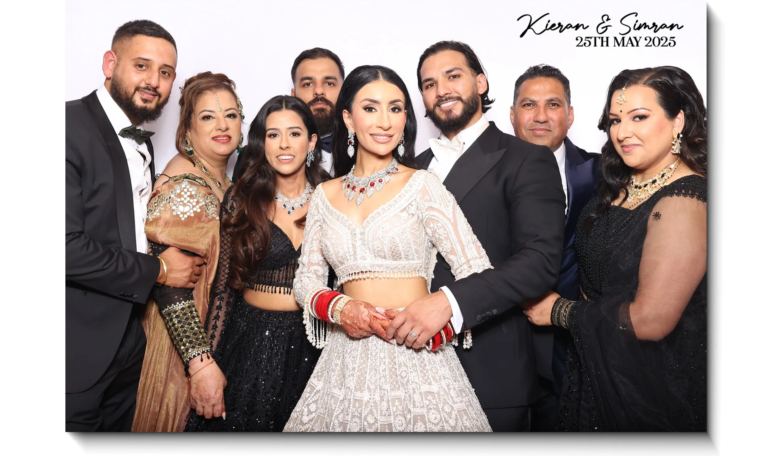A wedding party gathered in the booth, printed with the couple’s names and date